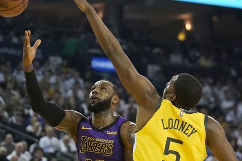 Los Angeles Lakers forward LeBron James (23) drives to the basket against Golden State Warriors forward Kevon Looney (5) during the first half of an NBA basketball game Tuesday, Dec. 25, 2018, in Oakland, Calif. (AP Photo/Tony Avelar)