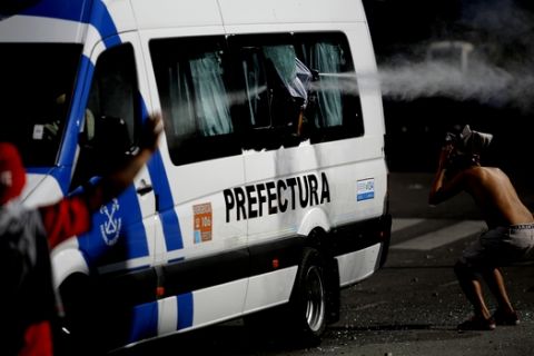 An Argentina River Plate fan is pepper sprayed from a moving police van prior the final soccer match of the Copa Libertadores between River Plate and Boca Juniors in Buenos Aires, Argentina, Saturday, Nov. 24, 2018. The final match of the Copa Libertadores has been pushed back after the bus carrying the Boca Juniors players was attacked by fans as it drove to the Antonio Vespucio Liberti stadium. (AP Photo/Sebastian Pani)