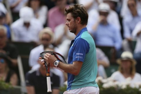 Switzerland's Stan Wawrinka carries the racket he just broke as he plays Spain's Rafael Nadal during their final match of the French Open tennis tournament at the Roland Garros stadium, Sunday, June 11, 2017 in Paris. (AP Photo/David Vincent)