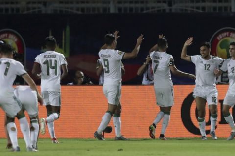 Algeria's Adam Ounas, second right, celebrates with his teammates after scoring his side's third goal during the African Cup of Nations round of 16 soccer match between Algeria and Guinea in 30 June stadium in Cairo, Egypt, Sunday, July 7, 2019. Algeria won 3-0. (AP Photo/Hassan Ammar)