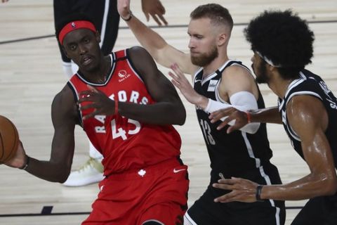 Toronto Raptors forward Pascal Siakam, left,  passes the ball against Brooklyn Nets guard Dzanan Musa, center, and center Jarrett Allen, right, during the first half of Game 4 of an NBA basketball first-round playoff series, Sunday, Aug. 23, 2020, in Lake Buena Vista, Fla. (Kim Klement/Pool Photo via AP)