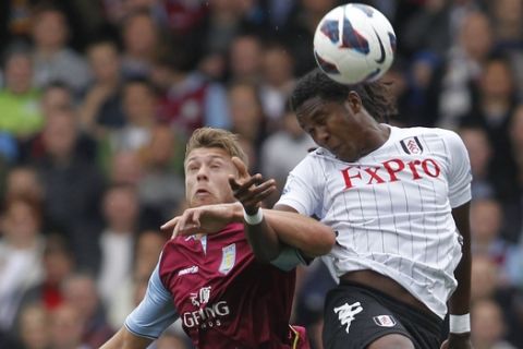 Fulham's Hugo Rodallega, right, competes with Aston Villa's Nathan Baker during their English Premier League soccer match at Craven Cottage, London, Saturday, Oct. 20, 2012. (AP Photo/Sang Tan)