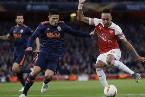 Arsenal's Pierre-Emerick Aubameyang, right, challenges for the ball with Valencia's Gabriel, during the Europa League semifinal first leg soccer match between Arsenal and Valencia at the Emirates stadium in London, Thursday, May 2, 2019. (AP Photo/Kirsty Wigglesworth)