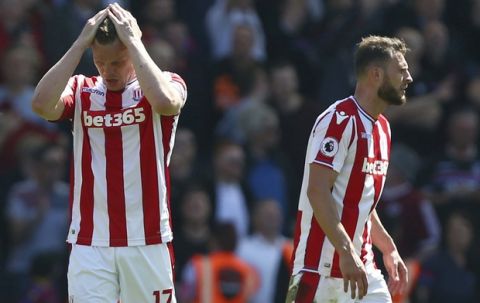 Stoke City's Ryan Shawcross, left, gestures after Crystal Palace's Patrick van Aanholt scores his side's second goal of the game,  during the English Premier League soccer match between Stoke City and Crystal Palace, at the bet365 Stadium, in Stoke, England, Saturday May 5, 2018. (Dave Thompson/PA via AP)