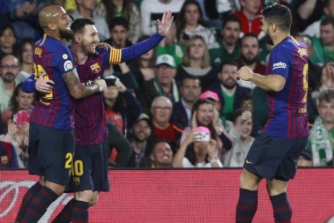 Barcelona's Messi, second left, celebrates after scoring with teammate Aleix Vidal, left, and Suarez during La Liga soccer match between Betis and Barcelona at the Benito Villamarin stadium in Seville, Spain, Sunday, March 17, 2019. (AP Photo/Miguel Morenatti)