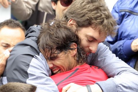 Spanish NBA player Pau Gasol, top, hugs compatriot and friend Rafael Nadal  after Nadal defeated Serbia's Novak Djokovic in their men's final match in the French Open tennis tournament at the Roland Garros stadium in Paris, Monday, June 11, 2012. Nadal Won 6-4, 6-3, 2-6, 7-5. (AP Photo/Bernat Armangue)