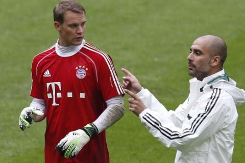 FC Bayern Munich head coach Pep Guardiola, right, talks to goalkeeper Manuel Neuer during his second soccer training session in the Allianz Arena stadium in Munich, southern Germany, on Thursday, June 27, 2013. (AP Photo/Matthias Schrader)