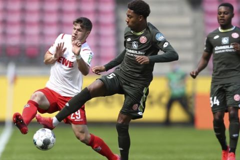 Jan Thielmann, left of 1. FC Koeln and Jean-Paul Boetius of FSV Mainz 05 challenge for the ball the German Bundesliga soccer match between 1. FC Cologne and FSV Mainz 05 in Cologne, Germany, Sunday, May 17, 2020. The German Bundesliga becomes the world's first major soccer league to resume after a two-month suspension because of the coronavirus pandemic. (AP Photo/Lars Baron, Pool)