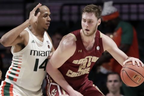 Boston College forward Nik Popovic (21) controls the ball as Miami center Rodney Miller Jr. (14) defends during the second half of an NCAA college basketball game, Wednesday, Feb. 12, 2020, in Coral Gables, Fla. Miami won 85-58. (AP Photo/Lynne Sladky)