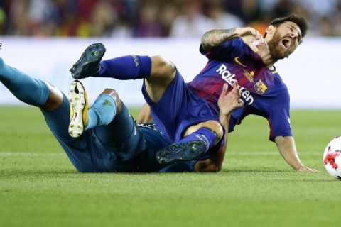 FC Barcelona's Lionel Messi is tackled during the Spanish Supercup, first leg, soccer match between FC Barcelona and Real Madrid at the Camp Nou stadium in Barcelona, Spain, Sunday, Aug. 13, 2017. (AP Photo/Manu Fernandez)