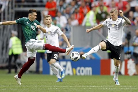 Mexico's Hector Herrera, left, vies for the ball with Germany's Toni Kroos during the group F match between Germany and Mexico at the 2018 soccer World Cup in the Luzhniki Stadium in Moscow, Russia, Sunday, June 17, 2018. (AP Photo/Victor R. Caivano)