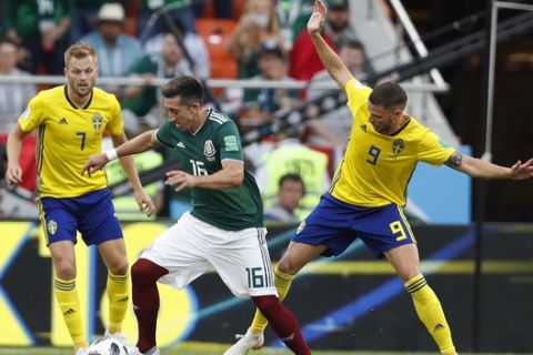 Mexico's Hector Herrera, center, Sweden's Sebastian Larsson, left, and Marcus Berg challenge for the ball during the group F match between Mexico and Sweden, at the 2018 soccer World Cup in the Yekaterinburg Arena in Yekaterinburg , Russia, Wednesday, June 27, 2018. (AP Photo/Eduardo Verdugo)