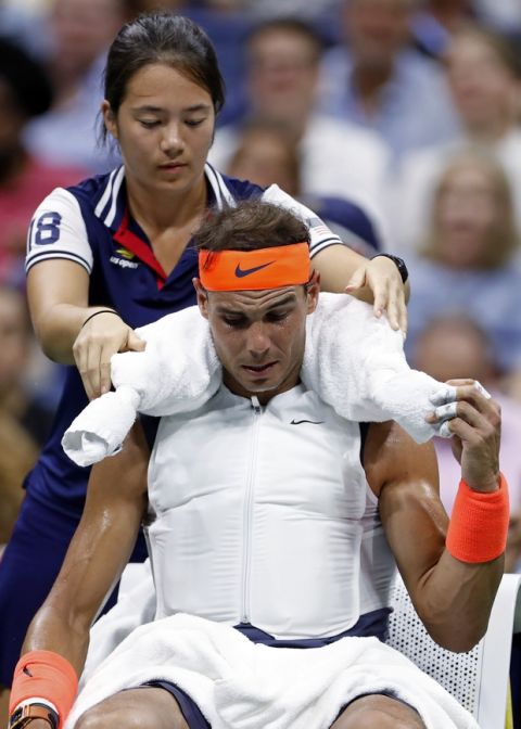 Rafael Nadal, of Spain, wears a cooling vest and has a towel with ice placed around his neck during a changeover in his match against Dominic Thiem, of Austria, during the quarterfinals of the U.S. Open tennis tournament Tuesday, Sept. 4, 2018, in New York. (AP Photo/Adam Hunger)