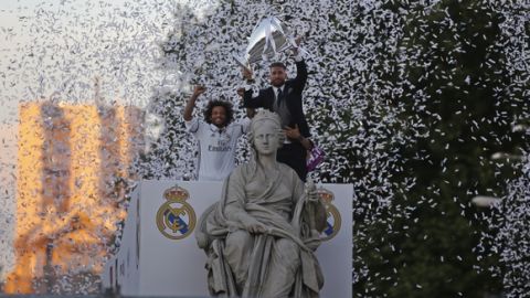 Real Madrid's Sergio Ramos, right, lifts the trophy next to Marcelo above the Cibeles goddess statue during celebrations in Cibeles square after winning the Champions League final, Madrid, Spain, Sunday June 4, 2017. Real Madrid became the first team in the Champions League era to win back-to-back titles with their 4-1 victory over Juventus in Cardiff Saturday. (AP Photo/Paul White)