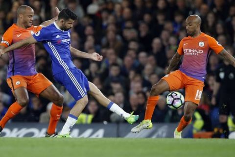 Chelsea's Diego Costa, center, vies for the ball with Manchester City's Vincent Kompany, left, and Fabian Delph, right, during the English Premier League soccer match between Chelsea and Manchester City at the Stamford Bridge stadium in London, Wednesday, April 5, 2017. (AP Photo/Alastair Grant)