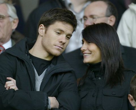 Liverpool's Xabi Alonso watches in the stands with a female companion