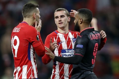 Arsenal's Alexandre Lacazette, right, hugs with Atletico's Antoine Griezmann, center, and Lucas Hernandez at the end of the Europa League semifinal, second leg soccer match between Atletico Madrid and Arsenal at the Metropolitano stadium in Madrid, Spain, Thursday, May 3, 2018. (AP Photo/Francisco Seco)