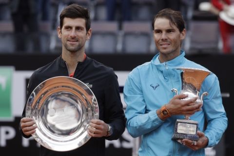 Rafael Nadal, right, of Spain and Novak Djokovic of Serbia pose with their trophies at the end of their final match at the Italian Open tennis tournament, in Rome, Sunday, May 19, 2019. (AP Photo/Gregorio Borgia)