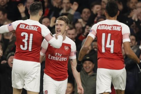 Arsenal's Aaron Ramsey, center, celebrates after scoring his side's first goal during the Europa League first leg quarterfinal soccer match between Arsenal and Napoli at Emirates stadium in London, Thursday, April 11, 2019. (AP Photo/Kirsty Wigglesworth)