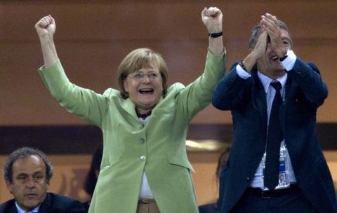 German Chancellor Angela Merkel, left, and German Soccer Federation President Wolfgang Niersbach celebrate during the Euro 2012 soccer championship quarterfinal match between Germany and Greece in Gdansk, Poland, Friday, June 22, 2012. Germany won 4-2. (AP Photo/Gero Breloer)