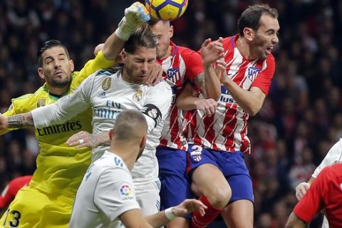 CAPTION CORRECTS THE ID: Real Madrids goalkeeper Kiko Casilla, center left, punches the ball clear during a Spanish La Liga soccer match between Atletico Madrid and Real Madrid at the Metropolitano stadium in Madrid, Spain, Saturday, Nov. 18, 2017. (AP Photo/Paul White)