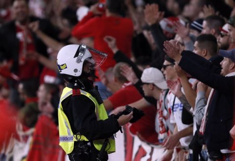 A police officer watches Cologne supporters during the Europa League group H soccer match between Arsenal and FC Cologne at the Emirates stadium in London, England, Thursday, Sept. 14, 2017 . (AP Photo/Kirsty Wigglesworth)