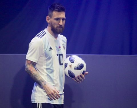 Argentinian national soccer team striker Lionel Messi poses with the official match ball for the 2018 FIFA World Cup Russia, named Telstar 18, during the unveiling ceremony in Moscow, Russia, Thursday, Nov. 9, 2017.  The Telstar 18 has a retro black-and-white design harking back to the original Adidas Telstar ball used for the 1970 World Cup, and Adidas says that in terms of structure, it's an evolution of the ball used for the last World Cup in 2014. (Oleg Shalmer)