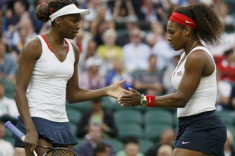 Serena Williams of the U.S. confers with her sister, Venus Williams (L), in the women's doubles tennis gold medal match against Czech Republic's Andrea Hlavackova and Lucie Hradecka at the London Olympic Games, August 5, 2012.   REUTERS/Stefan Wermuth (BRITAIN  - Tags: OLYMPICS SPORT TENNIS)  