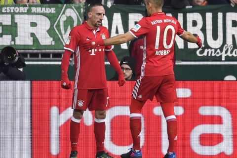 Bayern's Arjen Robben, right, celebrates after scoring the opening goal with assistant Franck Ribery, left, during the German Bundesliga soccer match between Werder Bremen and Bayern Munich in Bremen, Saturday, Jan. 28, 2017. (AP Photo/Martin Meissner)