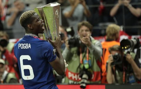 Manchester's Paul Pogba holds the trophy after winning 2-0 during the soccer Europa League final between Ajax Amsterdam and Manchester United at the Friends Arena in Stockholm, Sweden, Wednesday, May 24, 2017. (AP Photo/Michael Sohn)