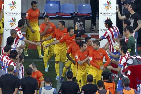 Barcelona players receive an honor greeting by Atletico de Madrid before the start of a Spanish La Liga soccer match at the Vicente Calderon stadium in Madrid, Spain Sunday May 12, 2013. Barcelona were proclaimed league champions Saturday night mathematically. (AP Photo/Chema Rey, Pool)