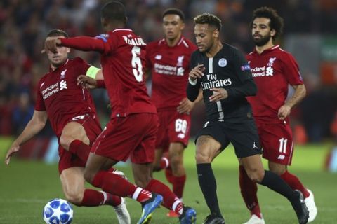 Liverpool's James Milner, left, moves the ball away from PSG's Neymar, second right, during the Champions League Group C soccer match between Liverpool and Paris-Saint-Germain at Anfield stadium in Liverpool, England, Tuesday, Sept. 18, 2018. (AP Photo/Dave Thompson)