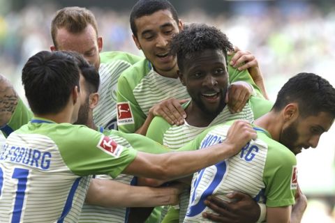 Wolfsburg's Divock Origi, second from right, celebrates after scoring his side's second goal in the German Bundesliga soccer match between VfB Wolfsburg and FC Cologne in Wolfsburg, northern Germany, Saturday, May 12, 2018. (Peter Steffen/dpa via AP)