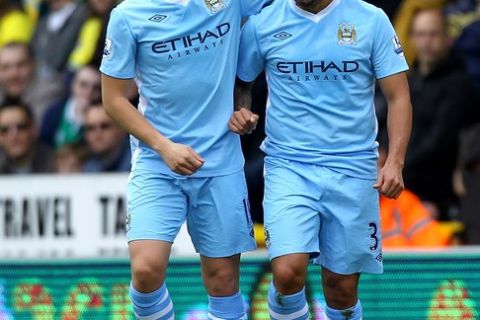 NORWICH, ENGLAND - APRIL 14:  Carlos Tevez of Manchester City celebrates scoring the opening goal with team mate Samir Nasri (L) during the Barclays Premier League match between Norwich City and Manchester City at Carrow Road on April 14, 2012 in Norwich, England.  (Photo by Matthew Lewis/Getty Images)