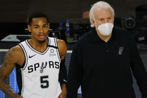 San Antonio Spurs head coach Gregg Popovich, right, talks with Dejounte Murray (5) during the first quarter of an NBA basketball game against the Utah Jazz, Thursday, Aug. 13, 2020, in Lake Buena Vista, Fla. (Kevin C. Cox/Pool Photo via AP)