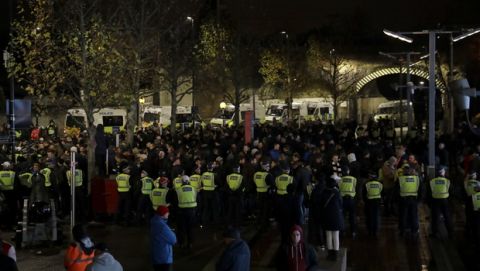 Police form a line around Eintracht Frankfurt fans, who are not allowed in the stadium after crowd trouble at their game against Vitoria Guimaraes in October, before the Europa League Group F soccer match between Arsenal and Eintracht Frankfurt outside the Emirates Stadium, in London, Thursday, Nov. 28, 2019. (AP Photo/Matt Dunham)