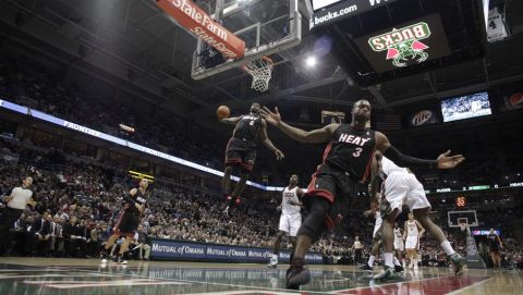Miami Heat's Dwyane Wade (3) reacts as teammate LeBron James (6) goes up for a dunk during the first half of an NBA basketball game against the Milwaukee Bucks Monday, Dec. 6, 2010, in Milwaukee. (AP Photo/Morry Gash)
