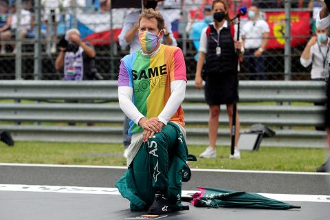 Aston Martin driver Sebastian Vettel of Germany takes a knee in support of the Black Lives Matter movement before the Hungarian Formula One Grand Prix at the Hungaroring racetrack in Mogyorod, Hungary, Sunday, Aug. 1, 2021. (Florion Goga/Pool via AP)
