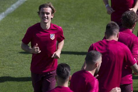 Atletico's Antoine Griezmann, left, runs back during exercises with team mates during a training session in Madrid, Spain Tuesday April 11, 2017. Atletico will play Leicester Wednesday in a Champions League quarterfinal, 1st leg soccer match in Madrid. (AP Photo/Paul White)