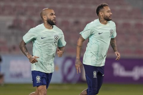 Brazil's Neymar, right, and Dani Alves attend a training session at the Grand Hamad stadium, in Doha, Qatar, Wednesday, Nov. 23, 2022. Brazil will play their first match in the World Cup against Serbia on Nov. 24. (AP Photo/Andre Penner)