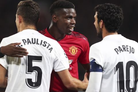 ManU midfielder Paul Pogba talks with Valencia defender Gabriel Paulista and midfielder Daniel Parejo, right, during the Champions League group H soccer match between Manchester United and Valencia at Old Trafford Stadium in Manchester, England, Tuesday Oct. 2, 2018. (AP Photo/Jon Super)