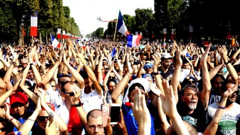Well-wishers prepare to cheer the victorious French team parading on the famed Champs Elysees avenue in Paris, France, after their 4-2 victory Sunday over Croatia to capture the trophy in the final of the FIFA World Cup, Monday, July 16, 2018. (AP Photo/Jean-Francois Badias)
