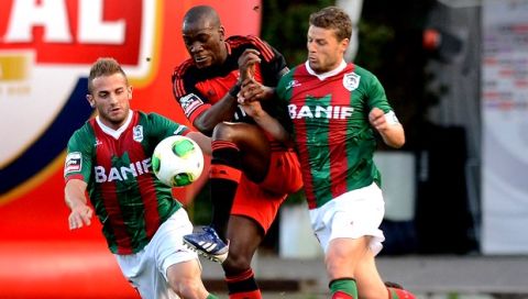 Benfica's Ola John, from the Netherlands, challenges Maritimo's Nuno "Briguel" Sousa, right, and Sergio Marakis, left, during their Portuguese League soccer match at Maritimo's Barreiros stadium in Funchal, on the Portuguese island of Madeira, Monday April 29, 2013. (AP Photo/Helder Santos)