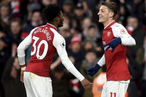 Arsenal's Mesut Ozil, right, celebrates scoring his side's first goal of the game with teammate Ainsley Maitland-Niles, during the English Premier League soccer match between Arsenal and Newcastle United, at the Emirates Stadium, in London, Saturday, Dec. 16, 2017. (Joe Giddens/PA via AP)