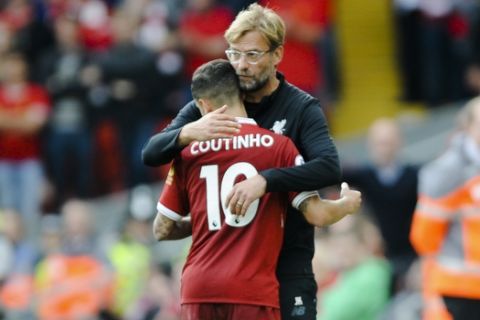Liverpool coach Juergen Klopp, right, embraces Liverpool's player Philippe Coutinho during the English Premier League soccer match between Liverpool and Manchester United at Anfield, Liverpool, England, Saturday, Oct. 14, 2017. (AP Photo/Rui Vieira)