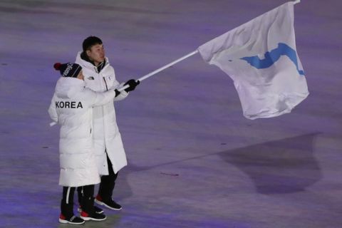 North Korea's Hwang Chung Gum and South Korea's Won Yun-jong walk onto the stage during the opening ceremony of the 2018 Winter Olympics in Pyeongchang, South Korea, Friday, Feb. 9, 2018. (AP Photo/Julie Jacobson)
