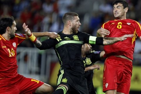 Spain's Sergio Ramos, center, jumps for the ball with Macedonia's Leonard Zhuta, left, and Vance Sikov during the Euro 2016 qualifying match between Macedonia and Spain at the Philip II stadium, in Skopje, Tuesday, Sept. 8, 2015. (AP Photo/Vlatko Perkovski)