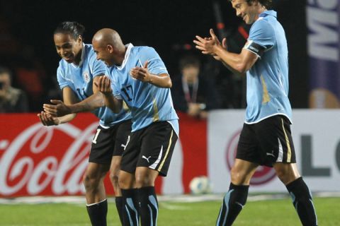 Uruguayan midfielder Alvaro Pereira (L) celebrates with teammate midfielder Egidio Arevalo Rios (C) after scoring against Mexico, as defender Diego Lugano claps behind them, during a 2011 Copa America Group C first round football match, at the Ciudad de La Plata stadium in La Plata, 59 Km south of Buenos Aires, on July 12, 2011.    AFP PHOTO / Maxi Failla (Photo credit should read Maxi Failla/AFP/Getty Images)