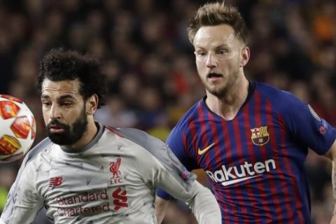 Liverpool's Mohamed Salah, left, eyes the ball past Barcelona's Ivan Rakitic during the Champions League semifinal, first leg, soccer match between FC Barcelona and Liverpool at the Camp Nou stadium in Barcelona, Spain, Wednesday, May 1, 2019. (AP Photo/Emilio Morenatti)