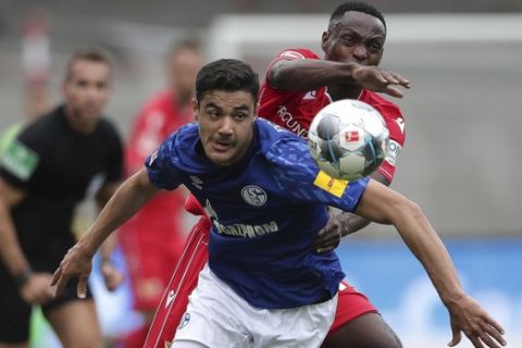 Schalke's Ozan Kabak, foreground, fights for the ball with Union's Anthony Ujah during the German Bundesliga soccer match between 1. FC Union Berlin and FC Schalke 04 in Berlin, Germany, Sunday, June 7, 2020. The German Bundesliga is the world's first major soccer league to resume after a two-month suspension because of the coronavirus pandemic. (AP Photo/Michael Sohn, Pool)